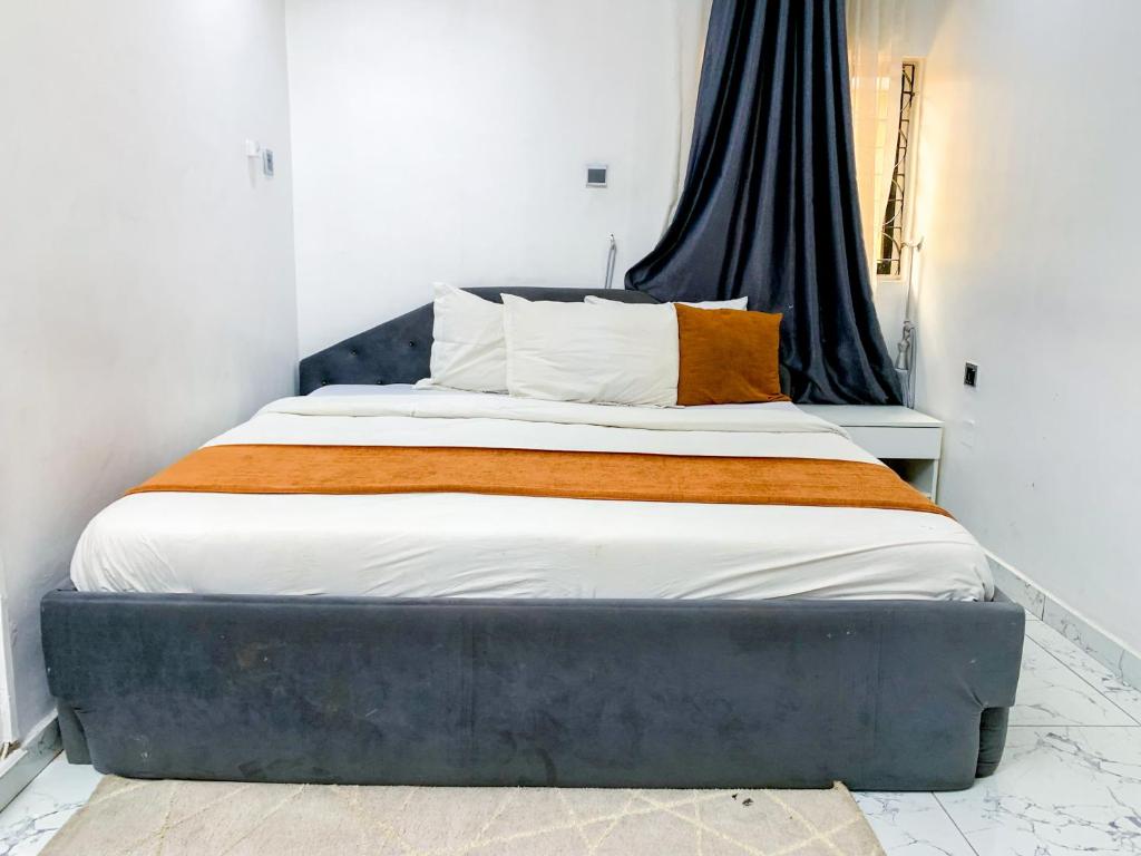 a bedroom with a bed with a blue headboard at Yardcourt 3Bedroom in Lagos