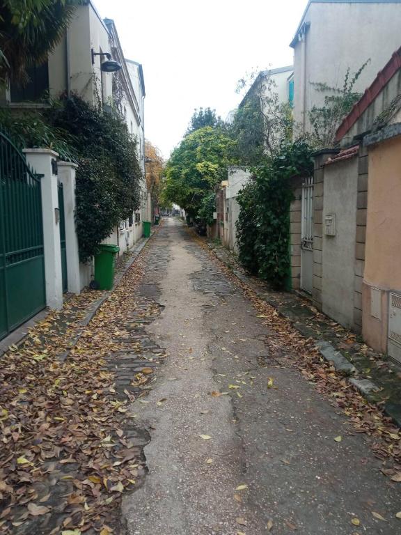 une ruelle vide avec des feuilles sur le sol dans l'établissement Le charles, à Paris