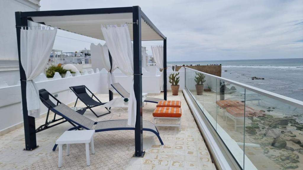 Un balcón con sillas y vistas al océano. en Dar Jean, en Asilah