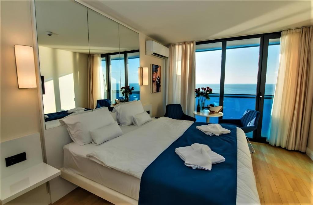 a bedroom with a large bed with a view of the ocean at PANORAMA ORBI City Center Suite Sea View in Batumi