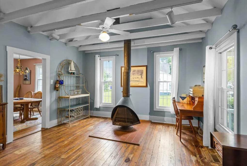 ein Wohnzimmer mit einem Holzofen in der Mitte in der Unterkunft Scuttlebutt Nautical Cottage in Beaufort