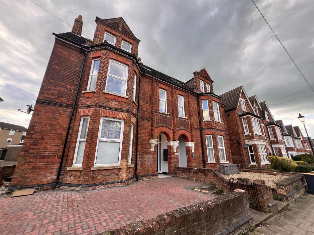 an old brick building on a city street at Comfortable Apartment Central Bedford FREE Parking & Private Garden in Bedford