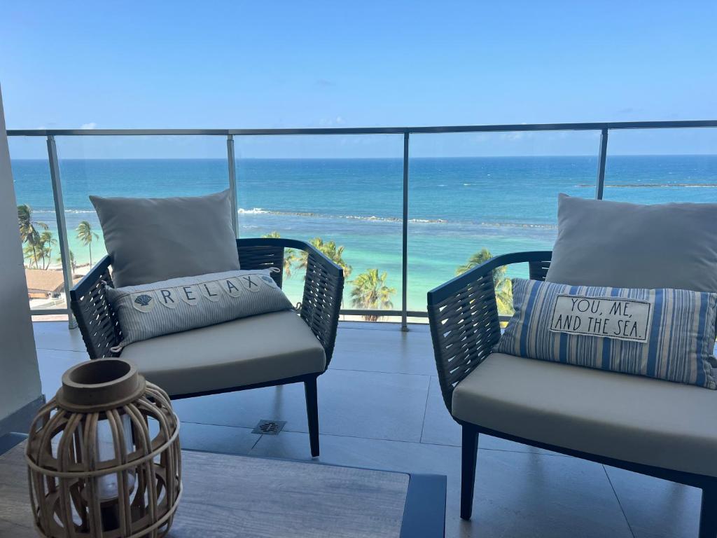 a balcony with chairs and a view of the ocean at Delux Oceanview on the Caribbean @ Playa Escondida Resort in María Chiquita