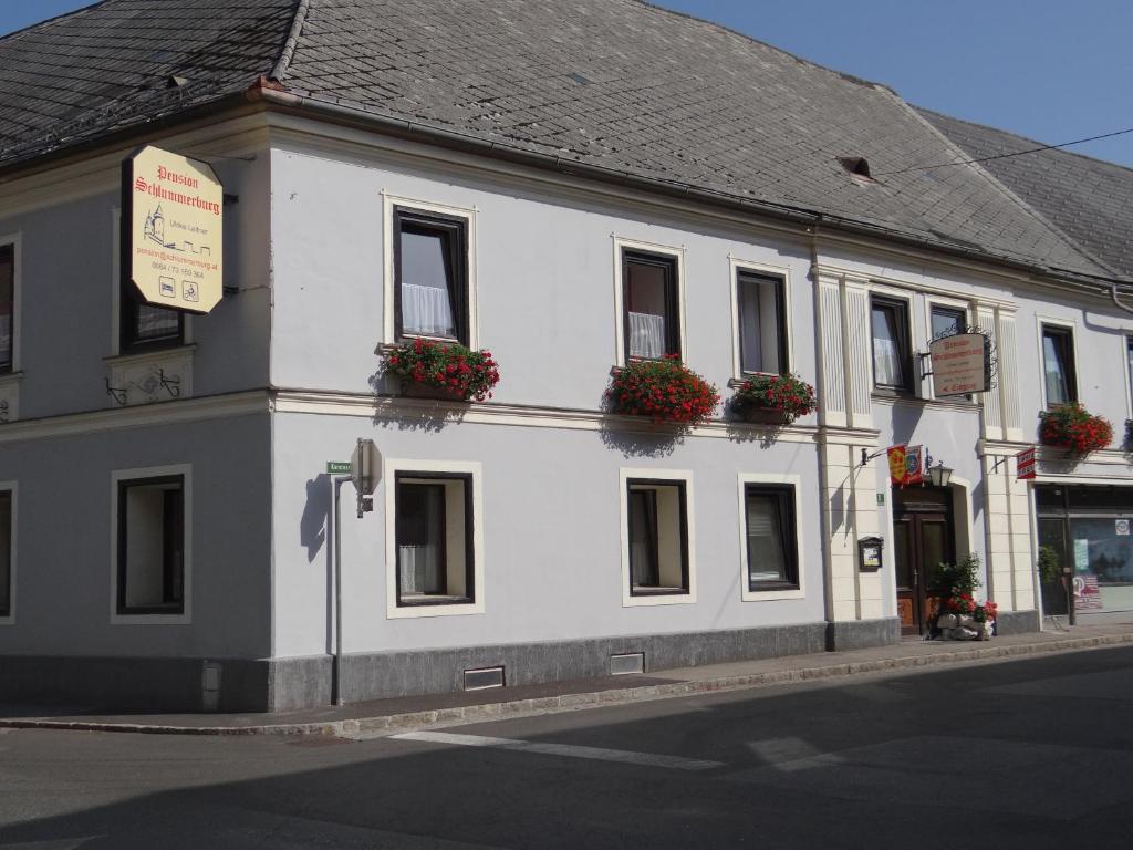 a white building with flower boxes on the windows at Schlummerburg in Weißkirchen in Steiermark