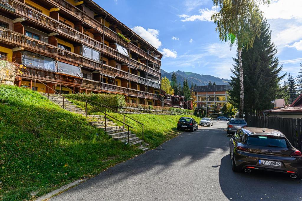 una calle con coches estacionados frente a un edificio en Apartment Marcus 2, en Poiana Brasov