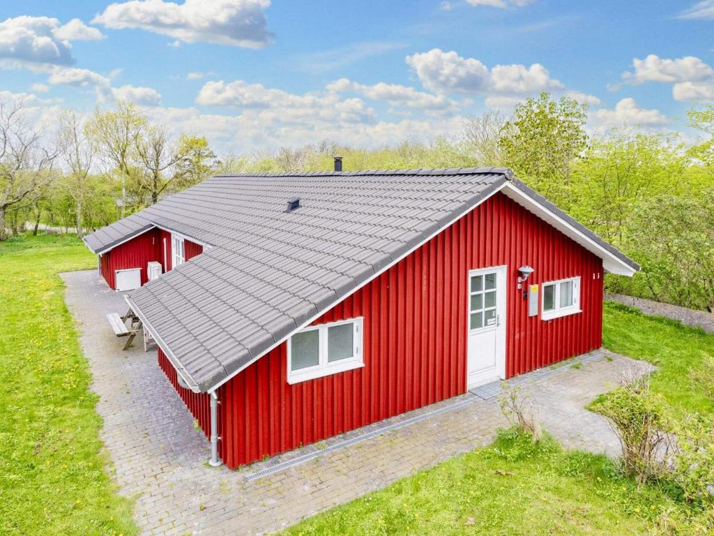 un granero rojo con un techo gris en un campo en 8 person holiday home in Vestervig en Vestervig