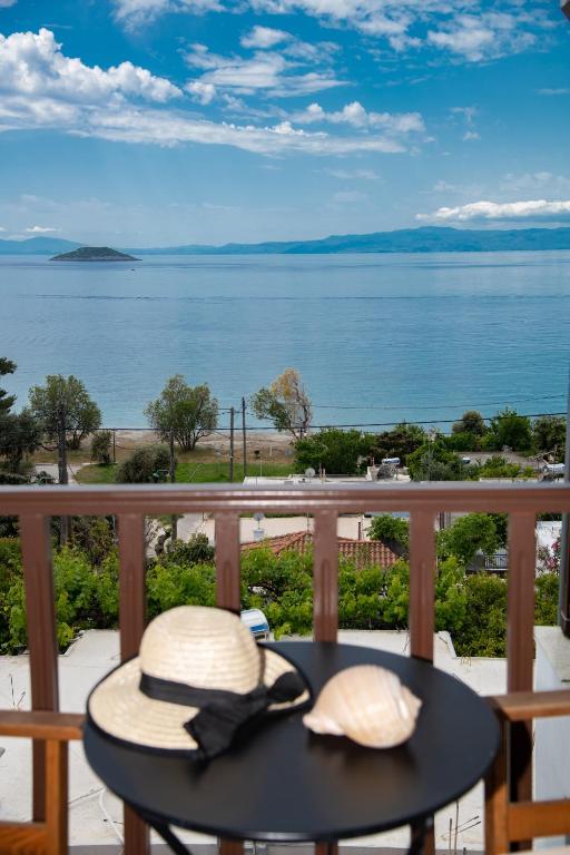 two hats sitting on a table on a balcony overlooking the water at Lilian Beach Front 3 Skopelos in Panormos Skopelos