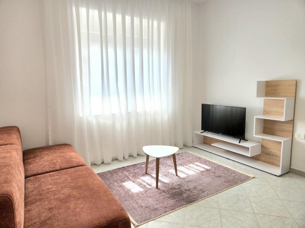 uma sala de estar com um sofá, uma televisão e uma mesa em Rustic City Center Vibes em Tirana