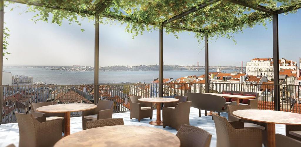 a restaurant with tables and chairs and a view of the water at Bairro Alto - Apartamento in Lisbon