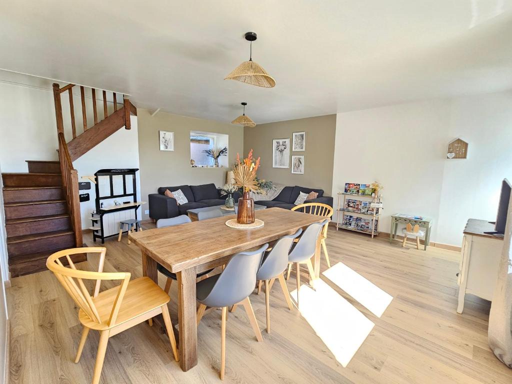 une salle à manger et un salon avec une table et des chaises dans l'établissement L'escapade, maison de campagne, à Étienville