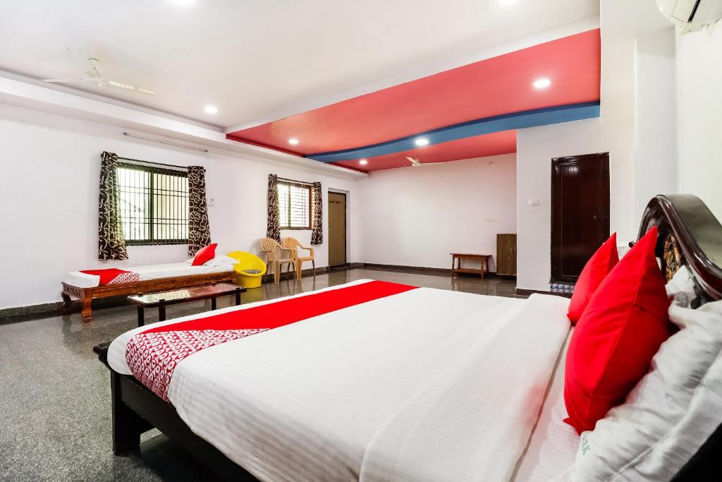 a bedroom with a large bed with red pillows at Collection O 67511 Golden Park in Proddatūr