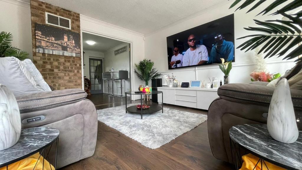 a living room with a couch and a tv at Lovely 3 bedroom house near city centre - Basildon in Basildon