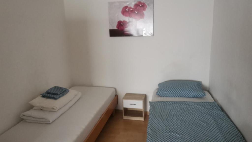 2 camas en una habitación pequeña con una foto en la pared en Zimmer am Marktplatz Wernberg en Wernberg-Köblitz