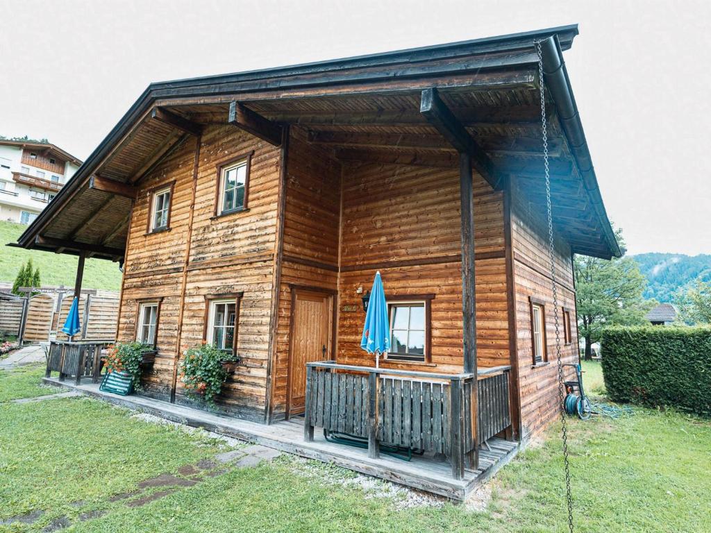 a log cabin with an umbrella in front of it at Urige Doppelhaushälfte 6 und 7 in Grafenweg