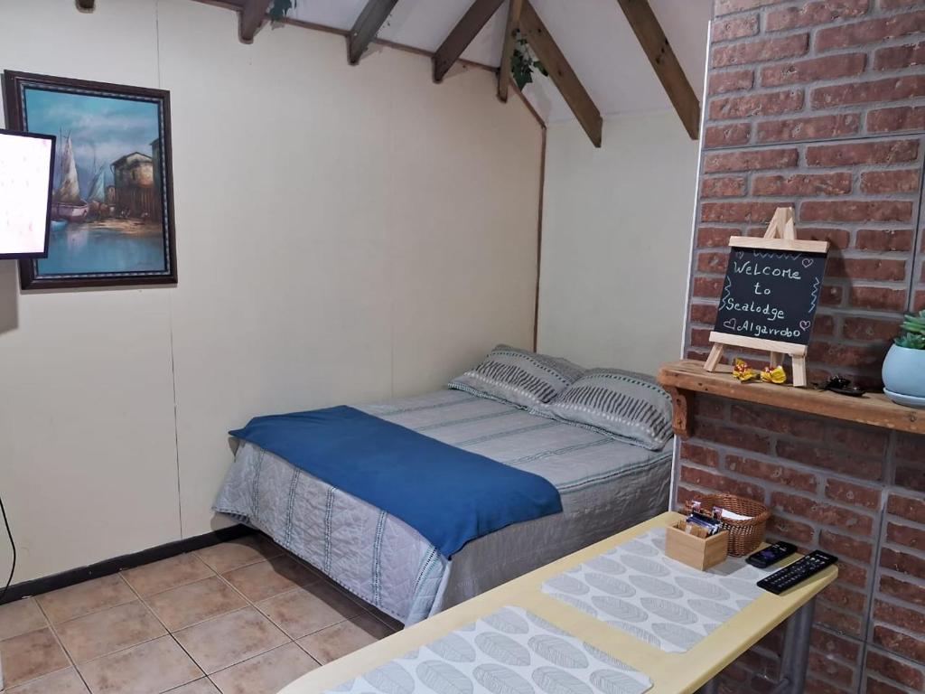 Dormitorio pequeño con cama y mesa en SEA LODGE ALGARROBO, en Algarrobo