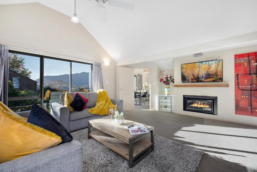 a living room with a couch and a fireplace at Distinctive Stylish and Spacious Family Home in Queenstown
