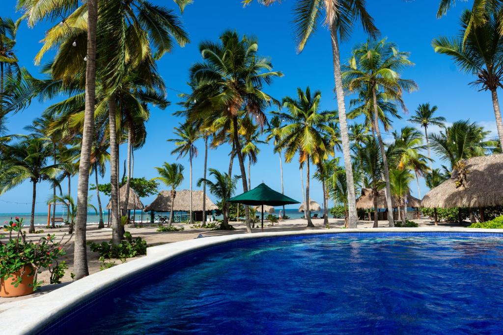 einen Pool am Strand mit Palmen in der Unterkunft Aite Eco Resort in Palomino