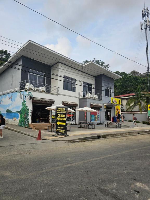 a building with tables and umbrellas in front of it at Pura vida apartments in Quepos