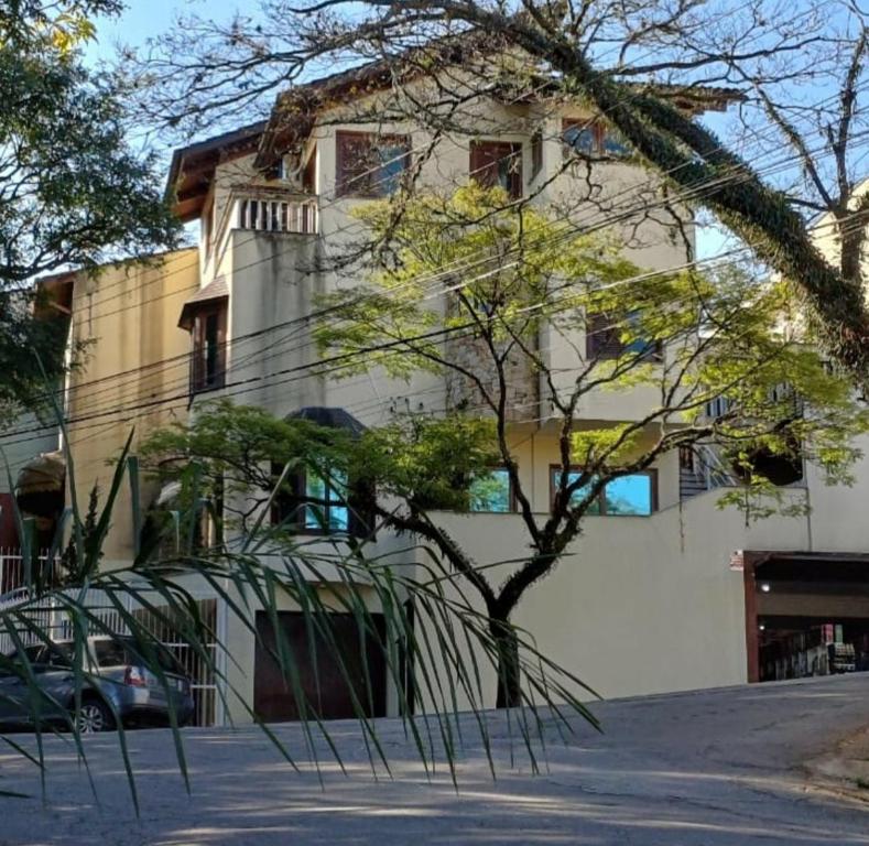 um edifício com uma árvore em frente em Pousada Monte Sião em São Paulo