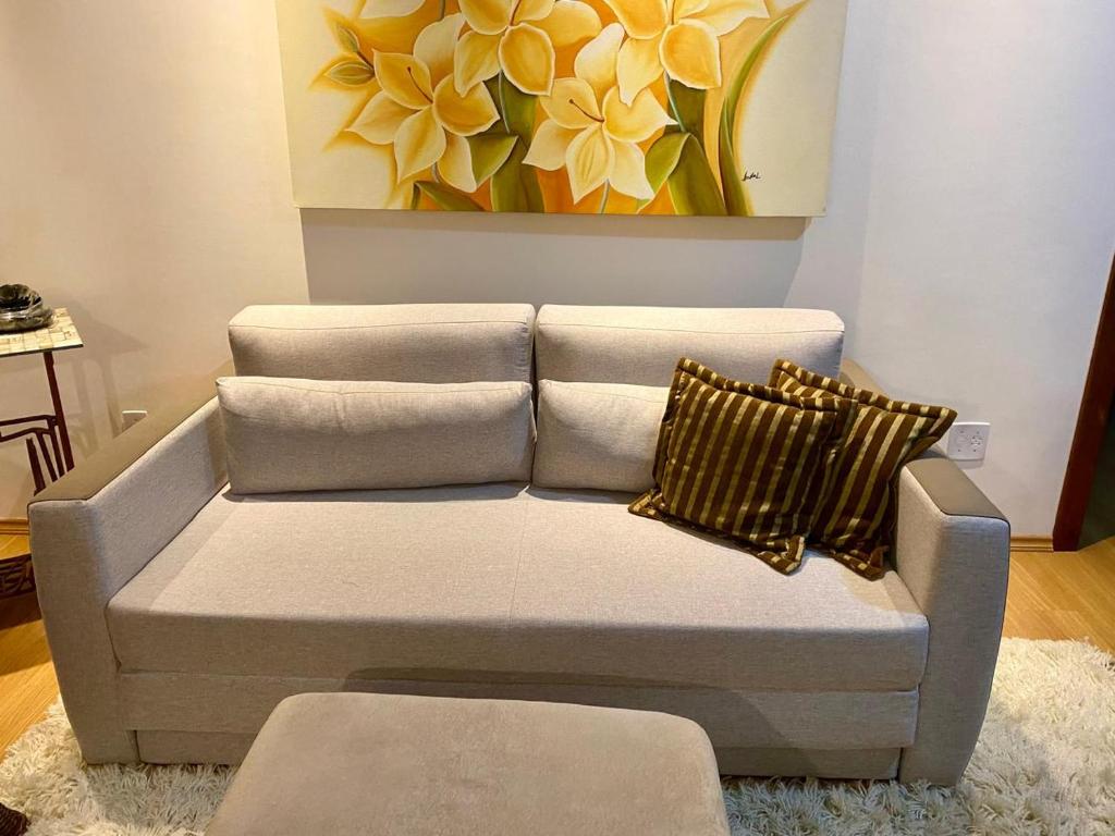 um sofá com duas almofadas numa sala de estar em Apartamento Lago Negro em Gramado