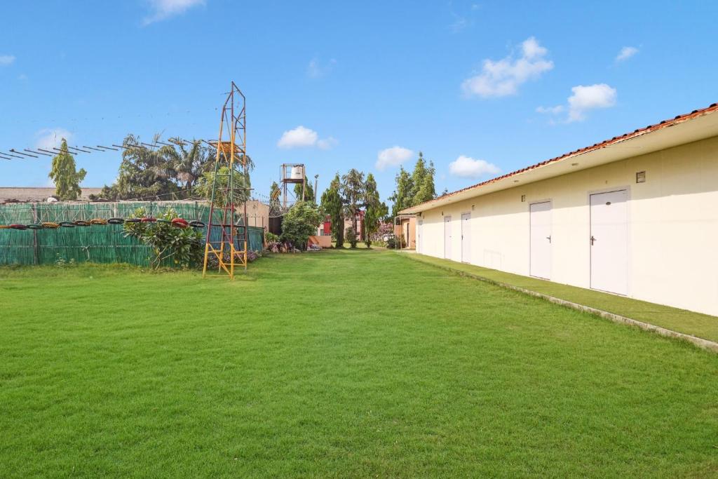 une grande pelouse avec un bâtiment et une aire de jeux dans l'établissement Palette - JPS Residency, à Gurgaon