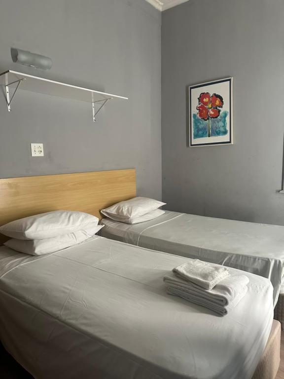 Dos camas en una habitación de hotel con toallas. en Hotel Internacional São Paulo, en São Paulo