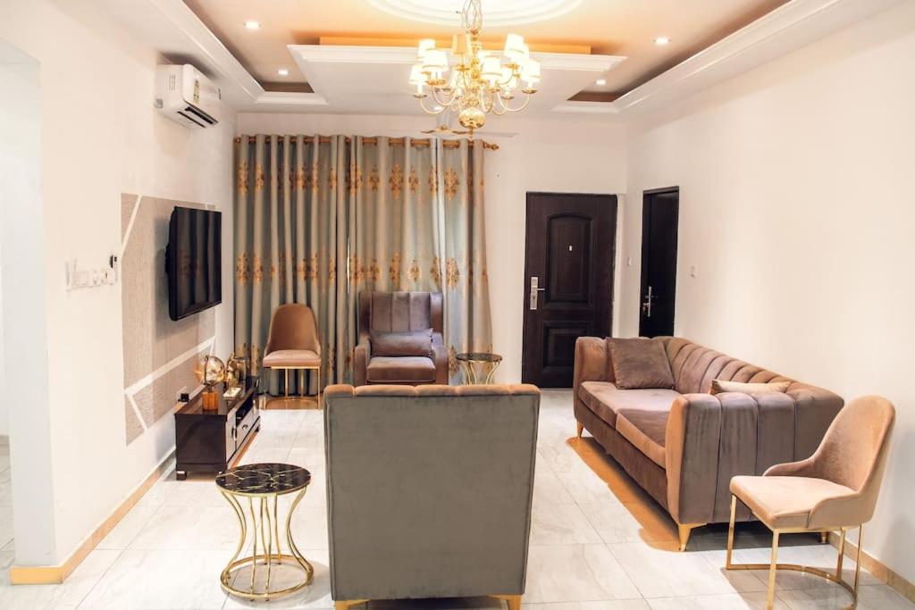 Stylish 2-bed Apartment Spintex في Kwedonu: غرفة معيشة مع أريكة وكرسي