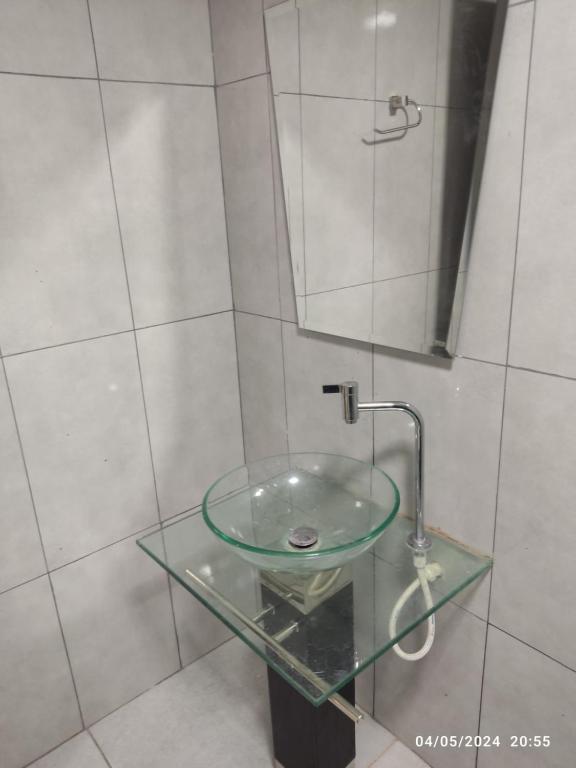 um lavatório de vidro num chuveiro com espelho em MEDPY HOSTEL em Pedro Juan Caballero