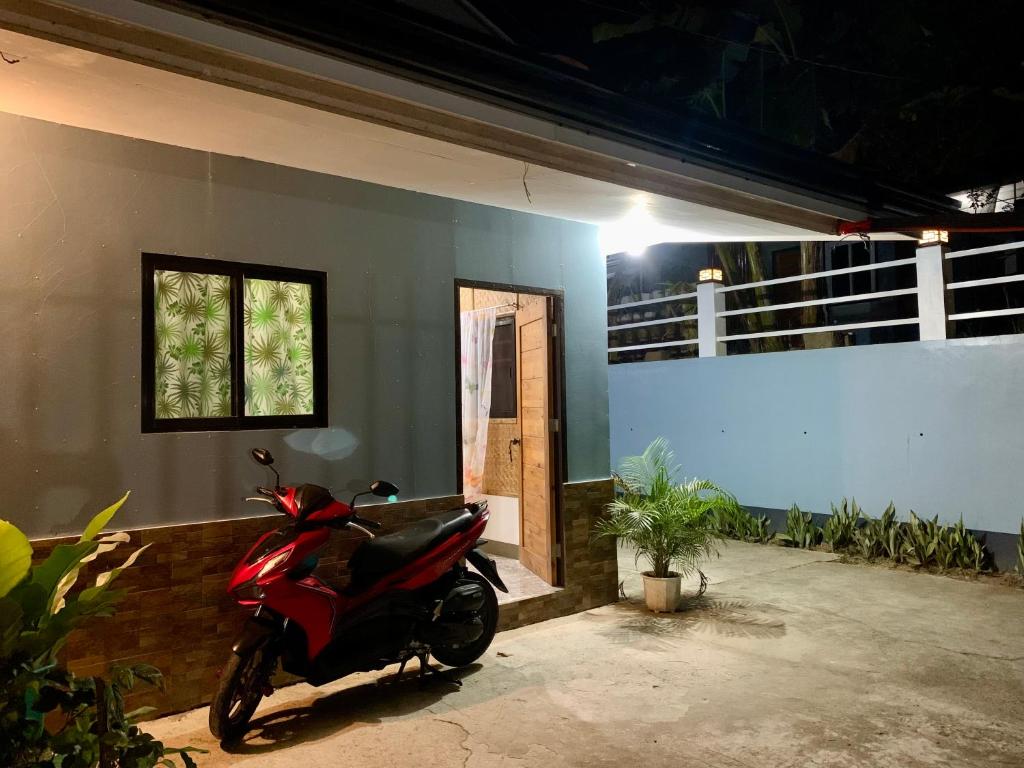 a red motorcycle parked in front of a house at Altheos Place Romblon Cottage 1 in Romblon