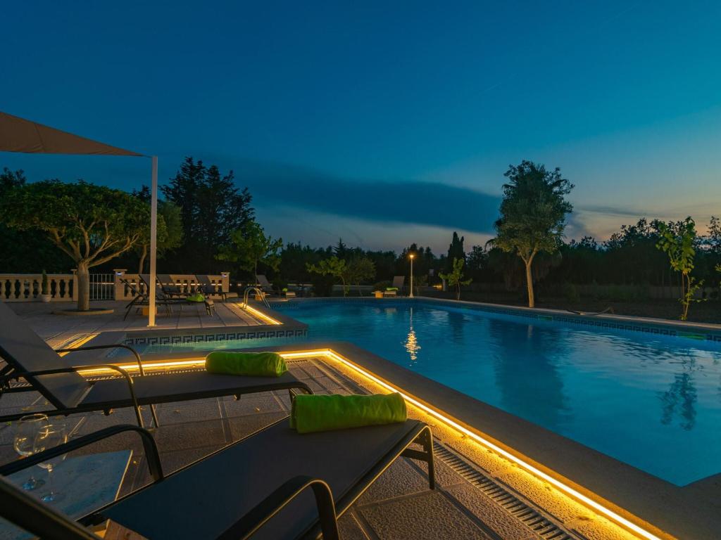 una piscina por la noche con 2 sillas y una mesa en Villa Arhu - Villa With Private Pool In Capdepera Free Wifi en Capdepera