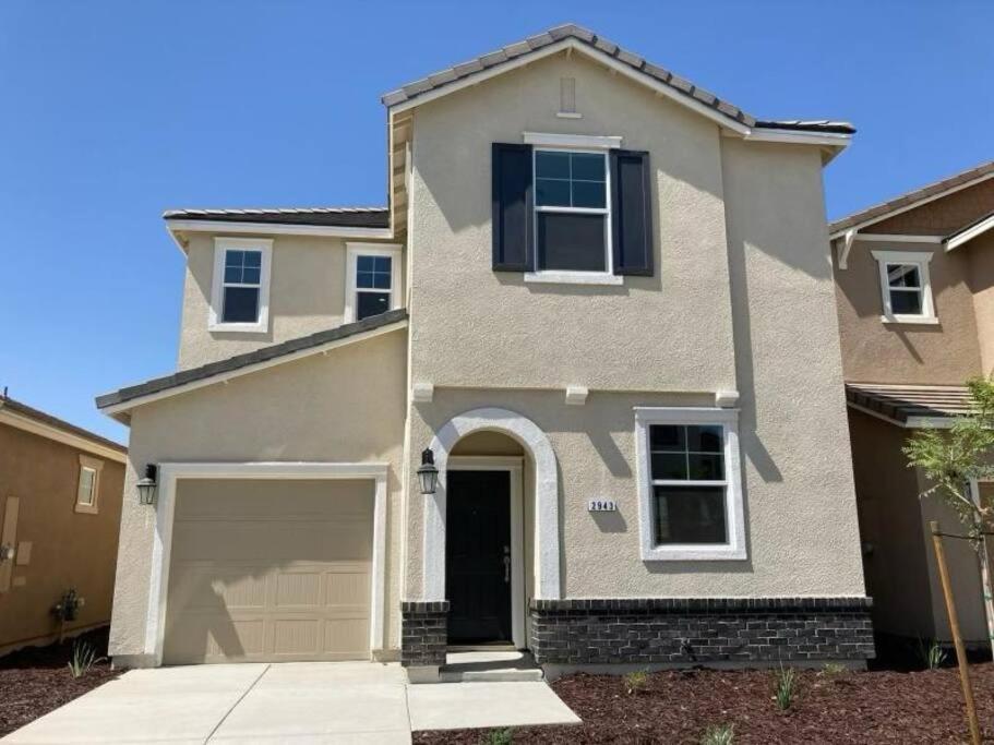 a house with a garage in front of it at Cozy Comforting Home in Merced