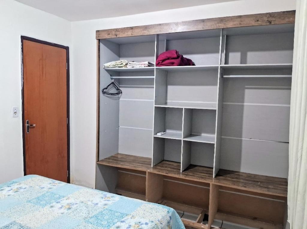 Cette chambre comprend un placard avec des étagères et un lit. dans l'établissement Apartamento aconchegante perto do shopping, à São Luís