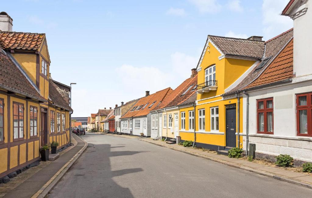 una calle vacía con edificios amarillos y blancos en Stunning Home In Rudkbing With Kitchen, en Rudkøbing
