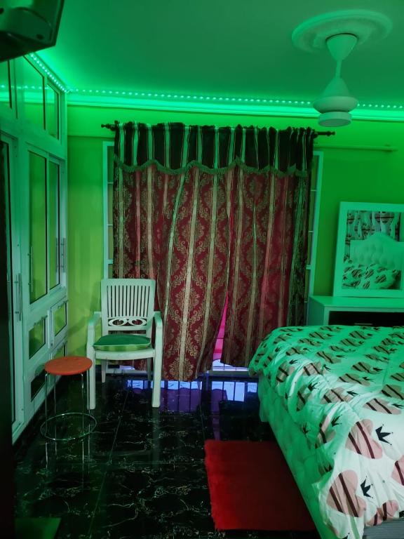 una camera verde con un letto e una sedia di Cómodo aparta estudio a Concepción de La Vega