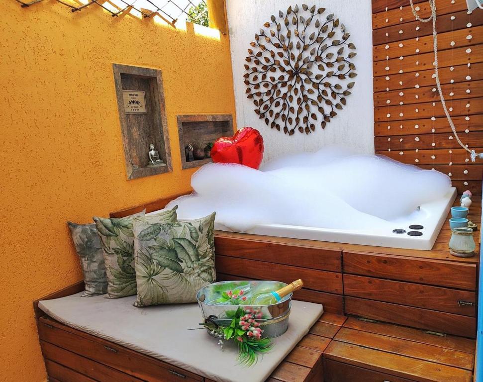 uma banheira sentada num banco de madeira num quarto em CasinhaPiri em Pirenópolis