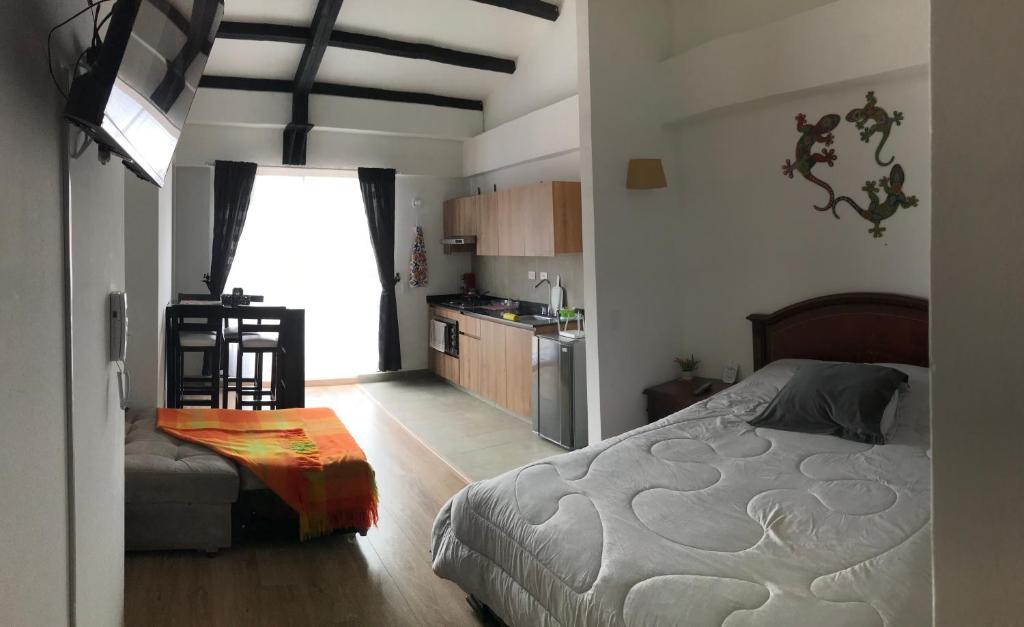 ein Schlafzimmer mit einem Bett und einer Küche darin in der Unterkunft Apartamento en La Candelaria, centro histórico Bogotá in Bogotá