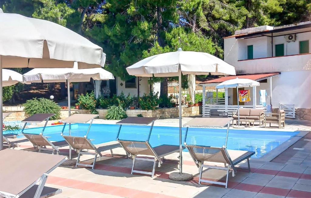 a pool with tables and chairs and umbrellas at Nice Apartment In Vieste With Wifi in Vieste