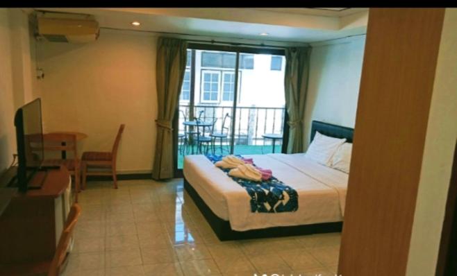 ホアヒンにあるthe L Hua Hinのベッドとバルコニー付きのホテルルーム