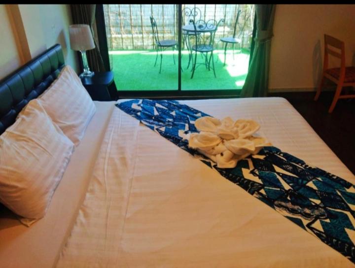 uma cama com uma flor em cima em the L Hua Hin em Hua Hin