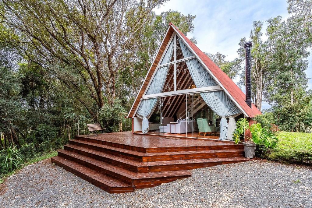 ein kleines Haus mit einem dreieckigen Dach und einer Treppe in der Unterkunft Chalé exclusivo à 19km do centro de Curitiba in Almirante Tamandaré