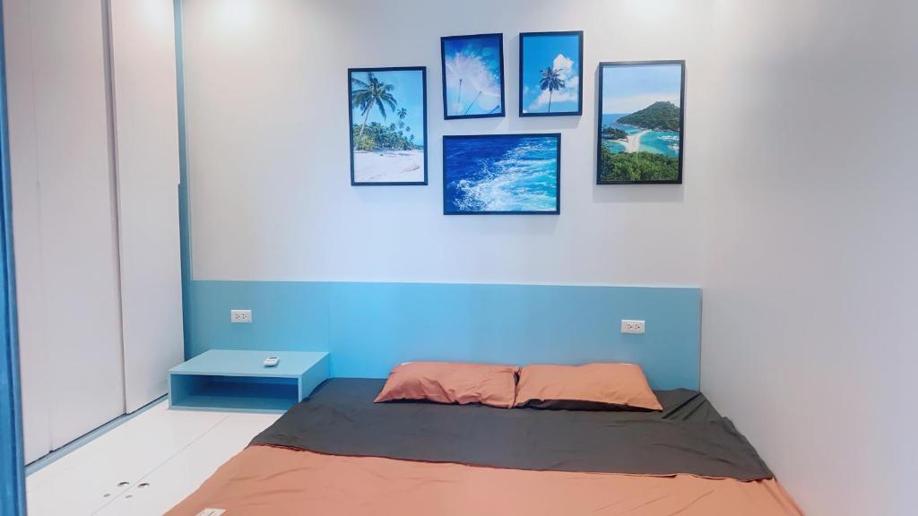 een bed in een kamer met foto's aan de muur bij Homestay Hạ Long in Ha Long