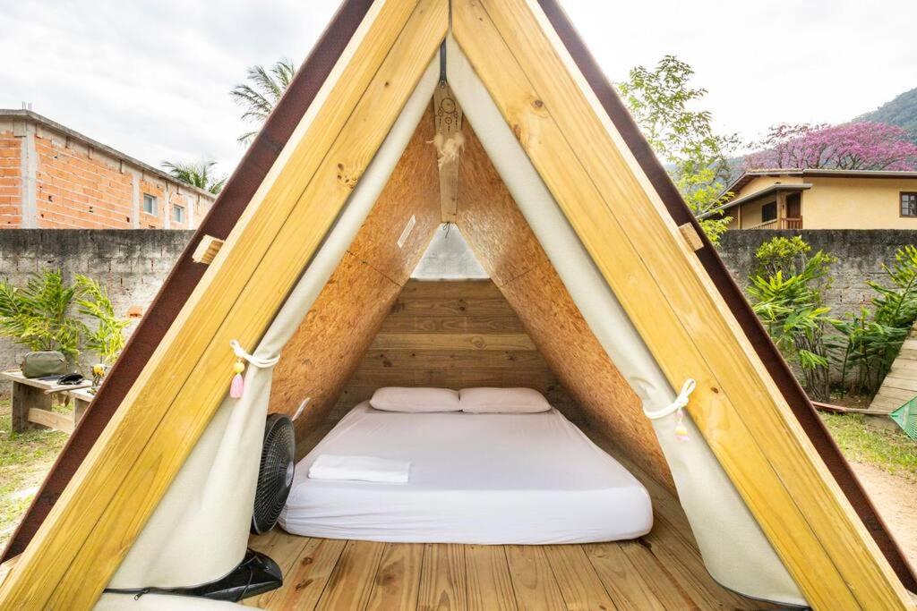 uma cama numa tenda num quintal em SURFSIDE MARESIAS em São Sebastião