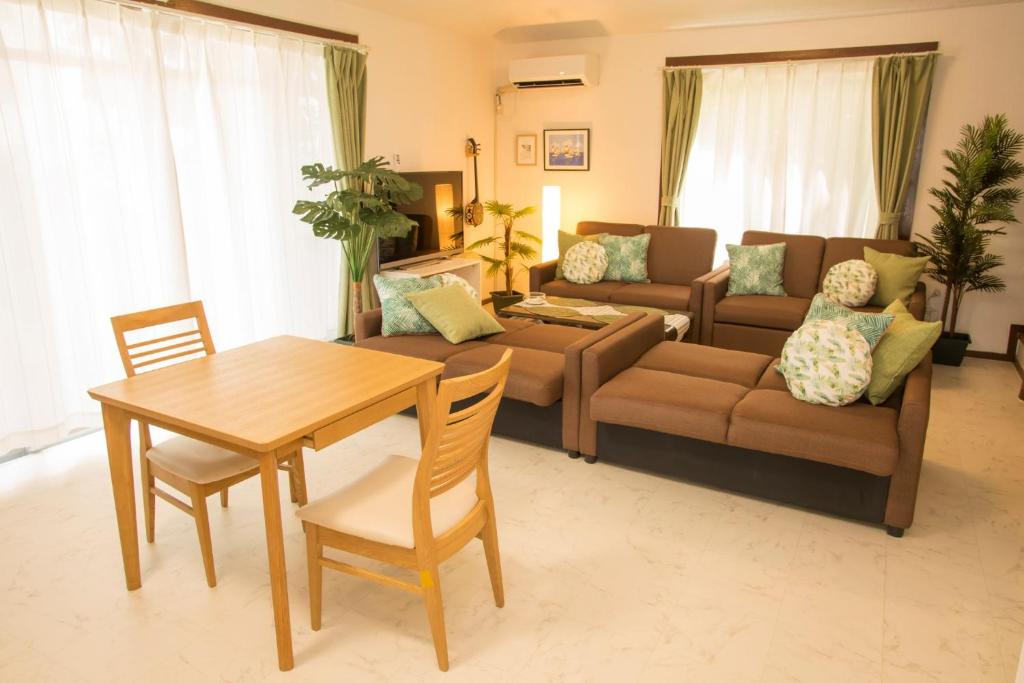 ein Wohnzimmer mit einem Sofa und einem Tisch in der Unterkunft Kunigami-gun - House / Vacation STAY 44423 in Motobu