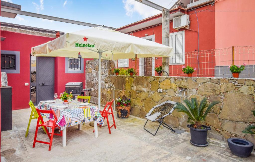 - une table et des chaises sous un parasol sur la terrasse dans l'établissement 2 Bedroom Awesome Home In Mitogio, à Gaggi