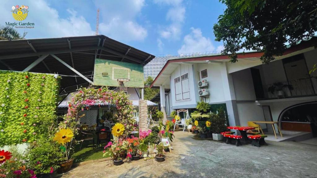 Magic Garden Residence Bangkok في بانكوك: منزل أمامه زهور ونباتات