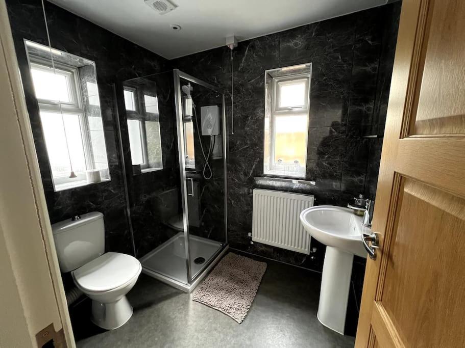 ein Bad mit einem WC, einer Dusche und einem Waschbecken in der Unterkunft 4 Bedroom House Coventry Sleep 7 with 3 Parking Spaces in Coventry