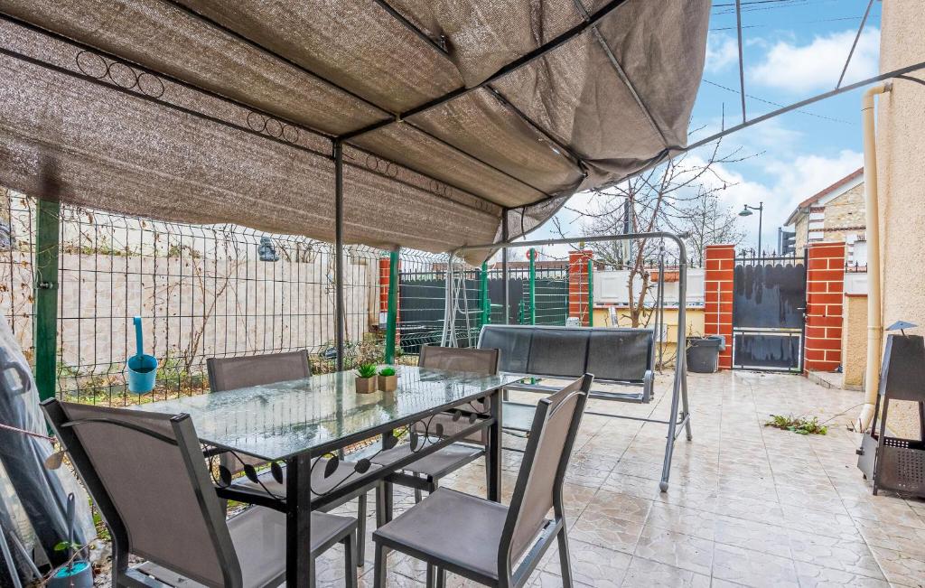 a patio with a glass table and chairs on a patio at Cozy Apartment In St Thibault Des Vignes With Kitchenette in Saint-Thibault-des-Vignes