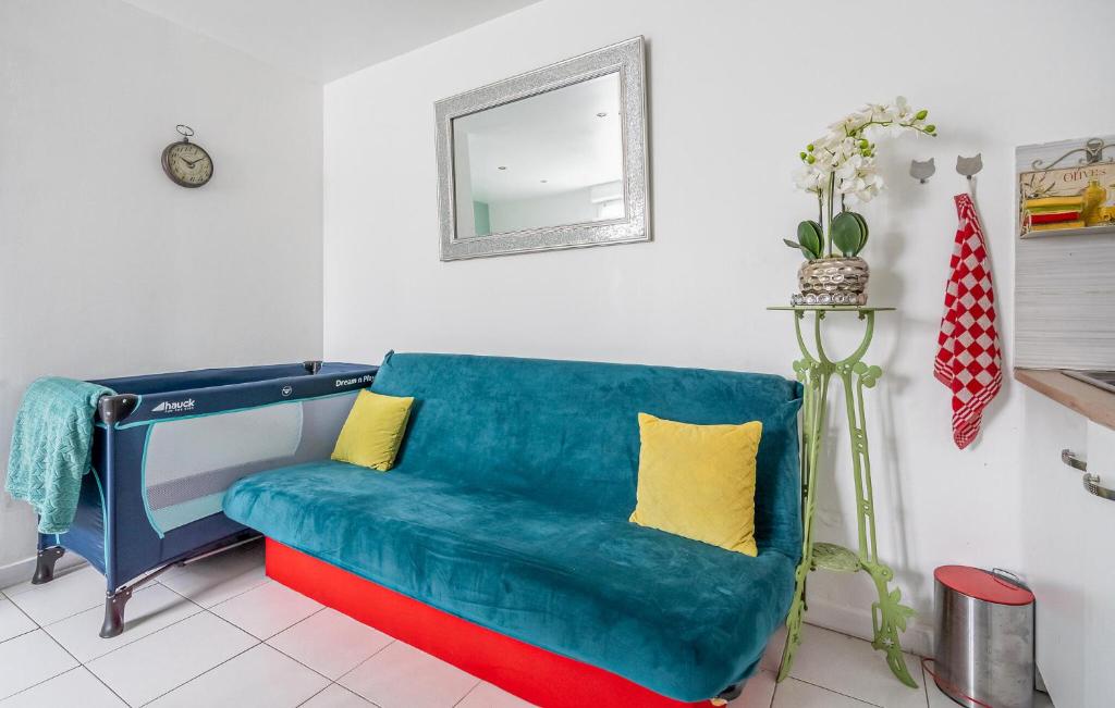 a living room with a blue couch and a mirror at Cozy Apartment In St Thibault Des Vignes With Kitchenette in Saint-Thibault-des-Vignes