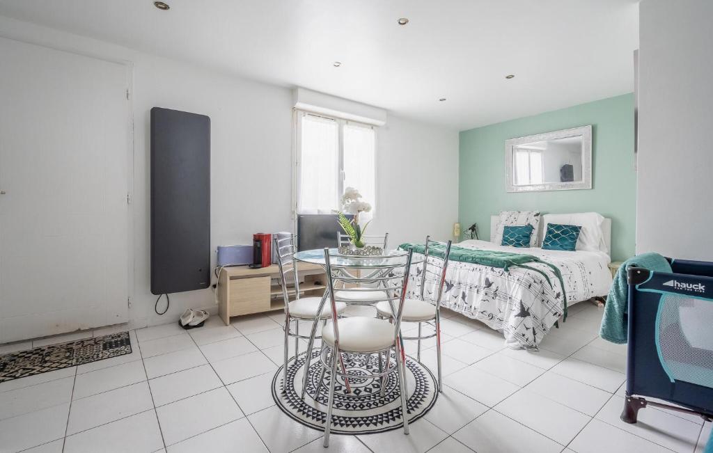 a bedroom with a bed and a table and a tv at Cozy Apartment In St Thibault Des Vignes With Kitchenette in Saint-Thibault-des-Vignes