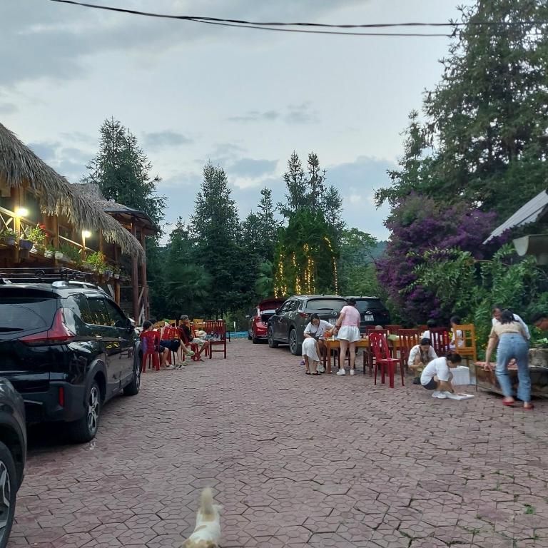 a group of people sitting at tables in a parking lot at Flower hmong homestay in Bắc Hà
